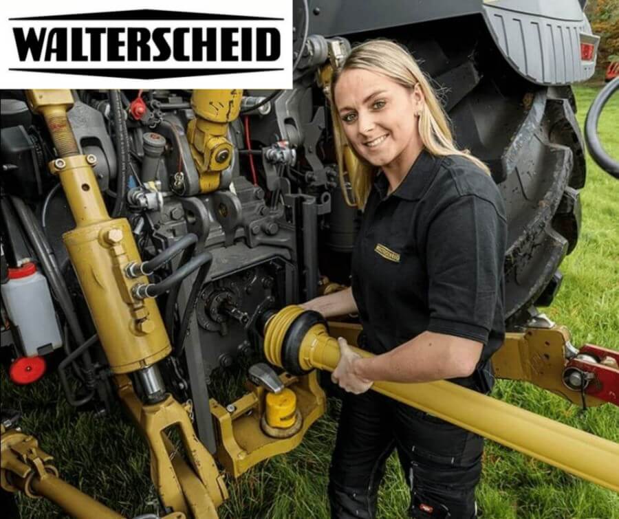 Female Walterscheid field technician connecting PTO driveline to tractor implement in agricultural field setting
